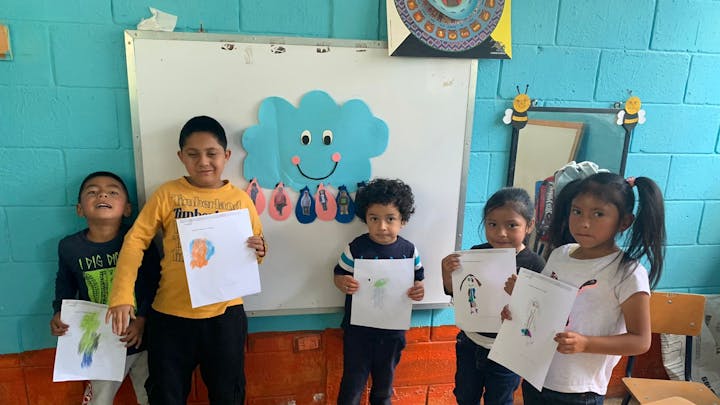 Kinderen laten een tekening zien op school in Guatemala.
