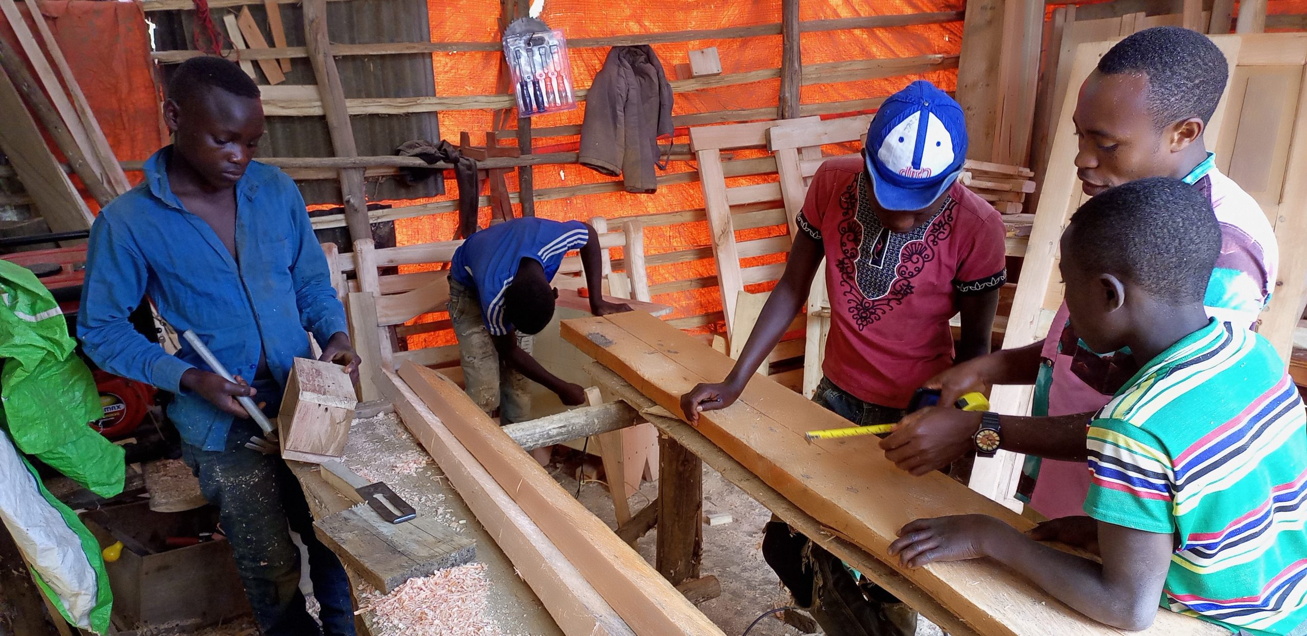 Een groep jongeren in een hout workshop.