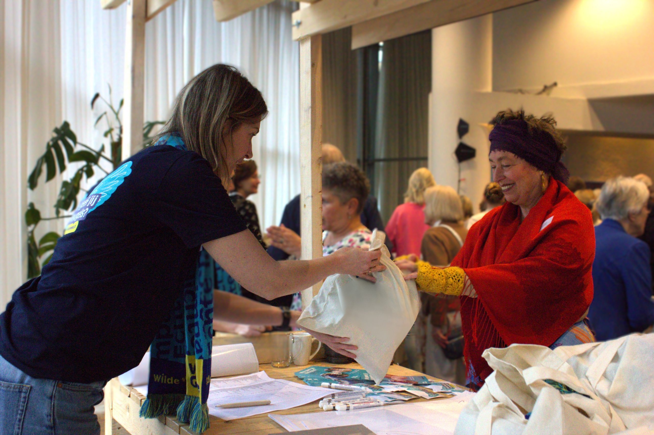 Een vrouw neemt een tas met spullen aan